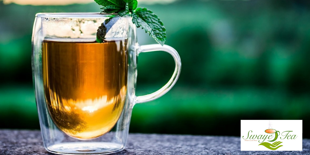 Photograph of Glass Cup with Hot Tea and Mint Leaves